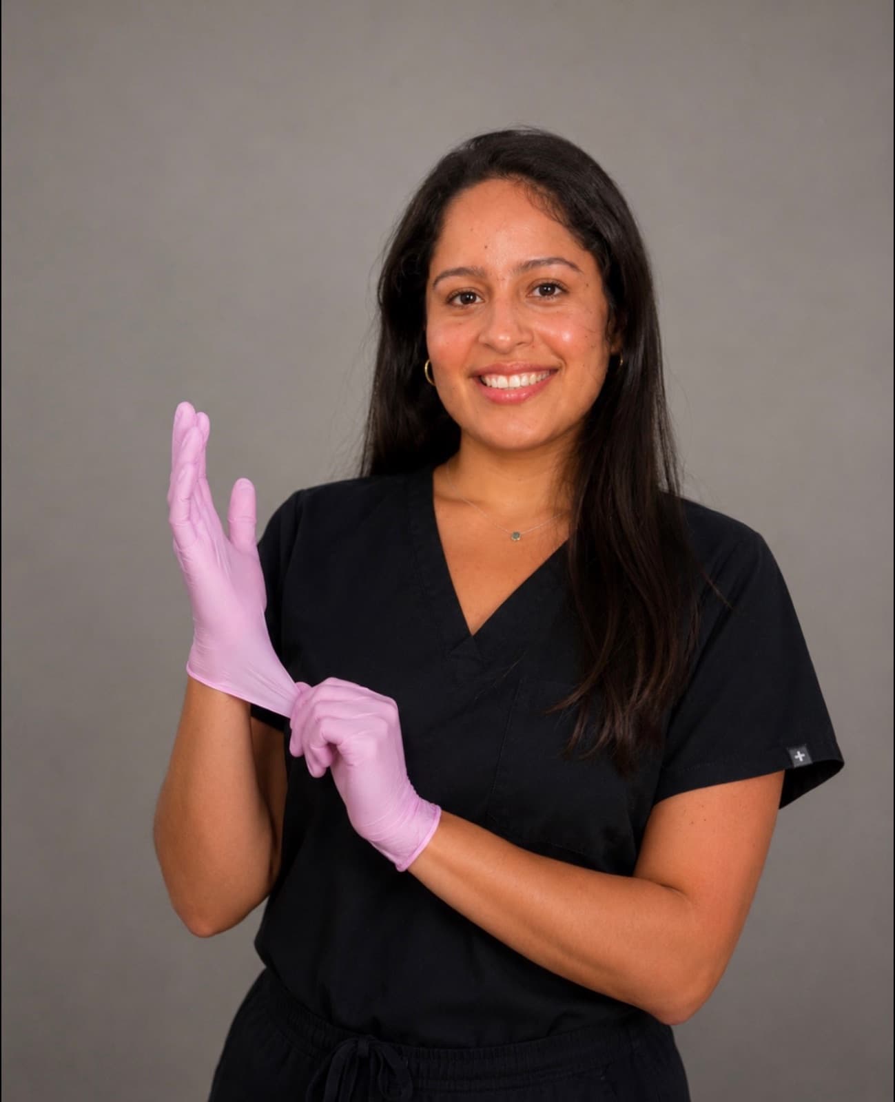 Anahi Ramos in black medical scrubs and pink gloves
